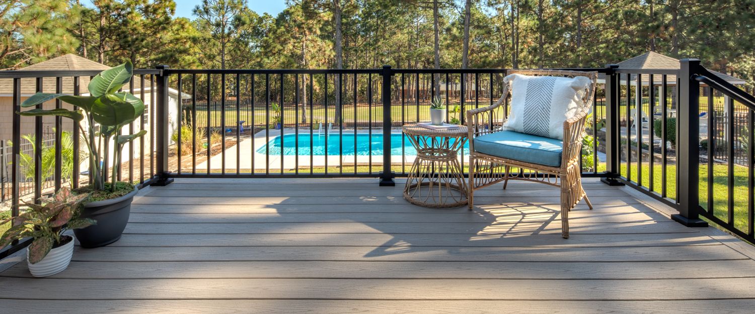Black Trex Signature aluminum railing around a poolside deck