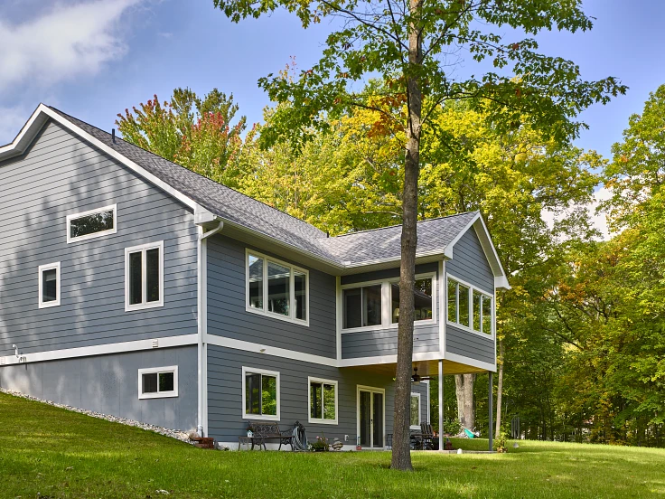Woodland home with gray RISE composite siding